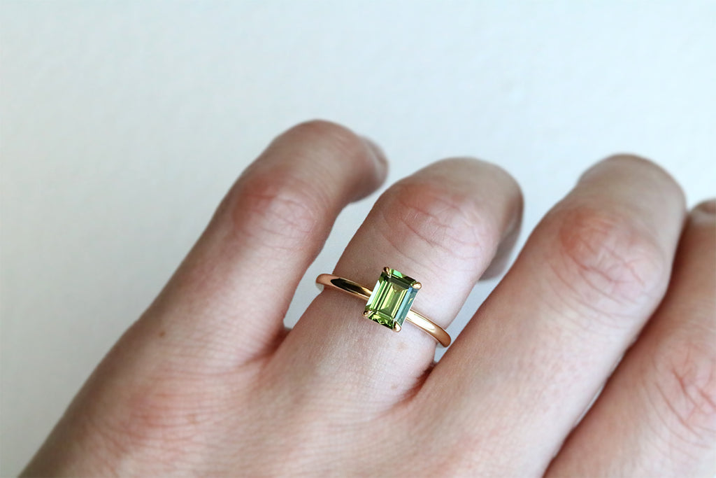 Handmade in 18ct yellow gold, this stunning solitaire engagement ring showcases a 1.60ct Emerald Cut Australian Green Sapphire.