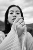 a model holding her hard towards the centre of the frame, she has rings on her fingers